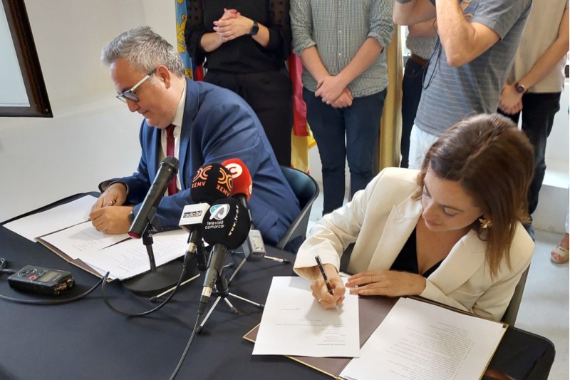 Els representats dels dos partits signant l’acord. 