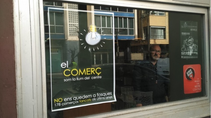 Un cartell de la protesta penjat en la porta d'un comerç del centre/AM