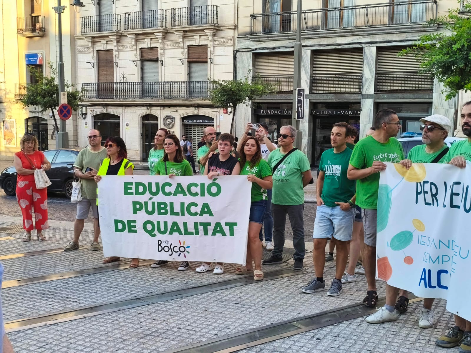 Concentració a la plaça amb la pancarta del CEIP El Bosco