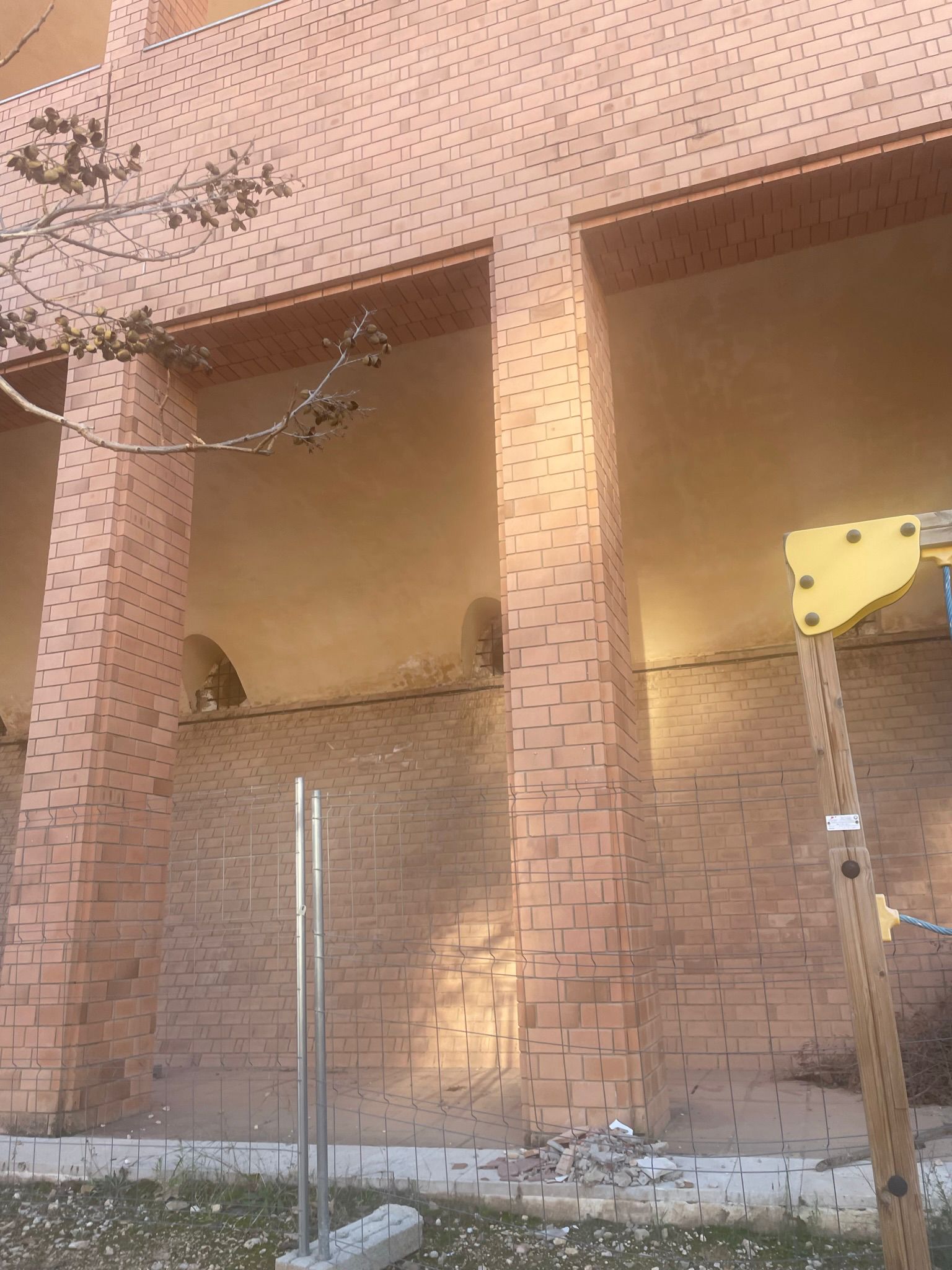 Façana amb caiguda de rajols a un pati tancat per seguretat al Romeral