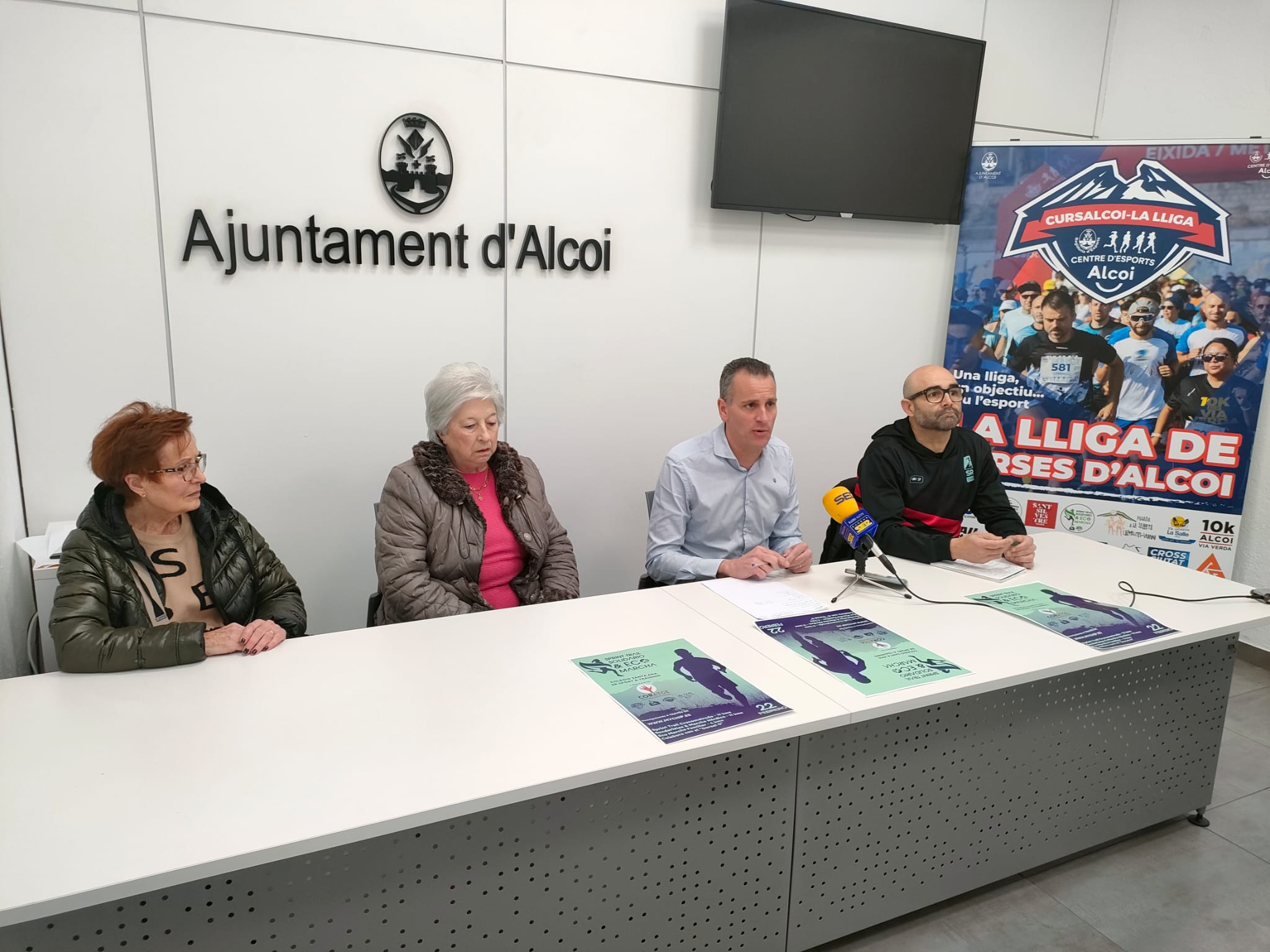 El regidor amb l'organigtzador de la cursa i dos representants de Cortage, l'associació beneficiària. 