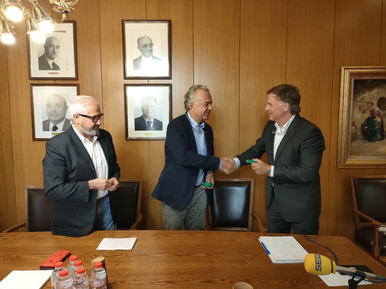 Rafael Pascual de l'Agrupació Tèxtil Alcoiana i Pascual Merita de la Fundació, es donen la mà. A l'esquerra, el regidor de patrimoni Ignacio Trelis. 